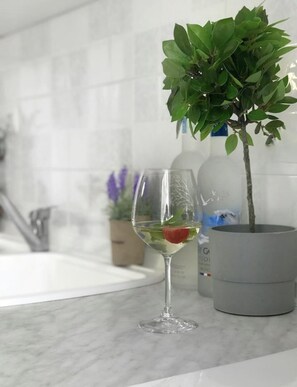 A kitchen counter with a potted plant, a wine glass with a strawberry, and a bottle of Gatorade. - Minimal Resort & Pool in Siviri, 150m From the Sea (Kassandra)