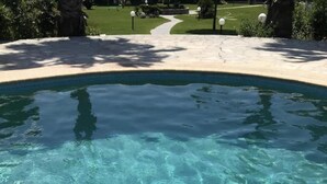 A clear swimming pool with a stone deck and a pathway leading to a grassy area. - Minimal Resort & Pool in Siviri, 150m From the Sea (Kassandra)