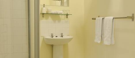 A bathroom with a shower, sink, and toilet.