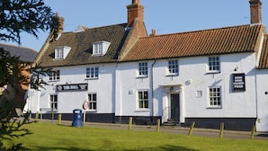 A white building with a sign reading "The Bull" and "Good Home Cooked Food". - The Litcham Bull Inn (King's Lynn)