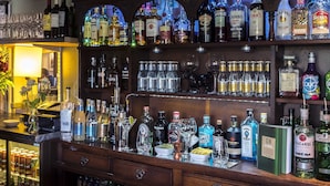A bar with shelves of liquor bottles and glasses. - The Litcham Bull Inn (King's Lynn)