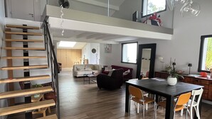 Een moderne woonruimte met een trap, een eethoek en een keuken.