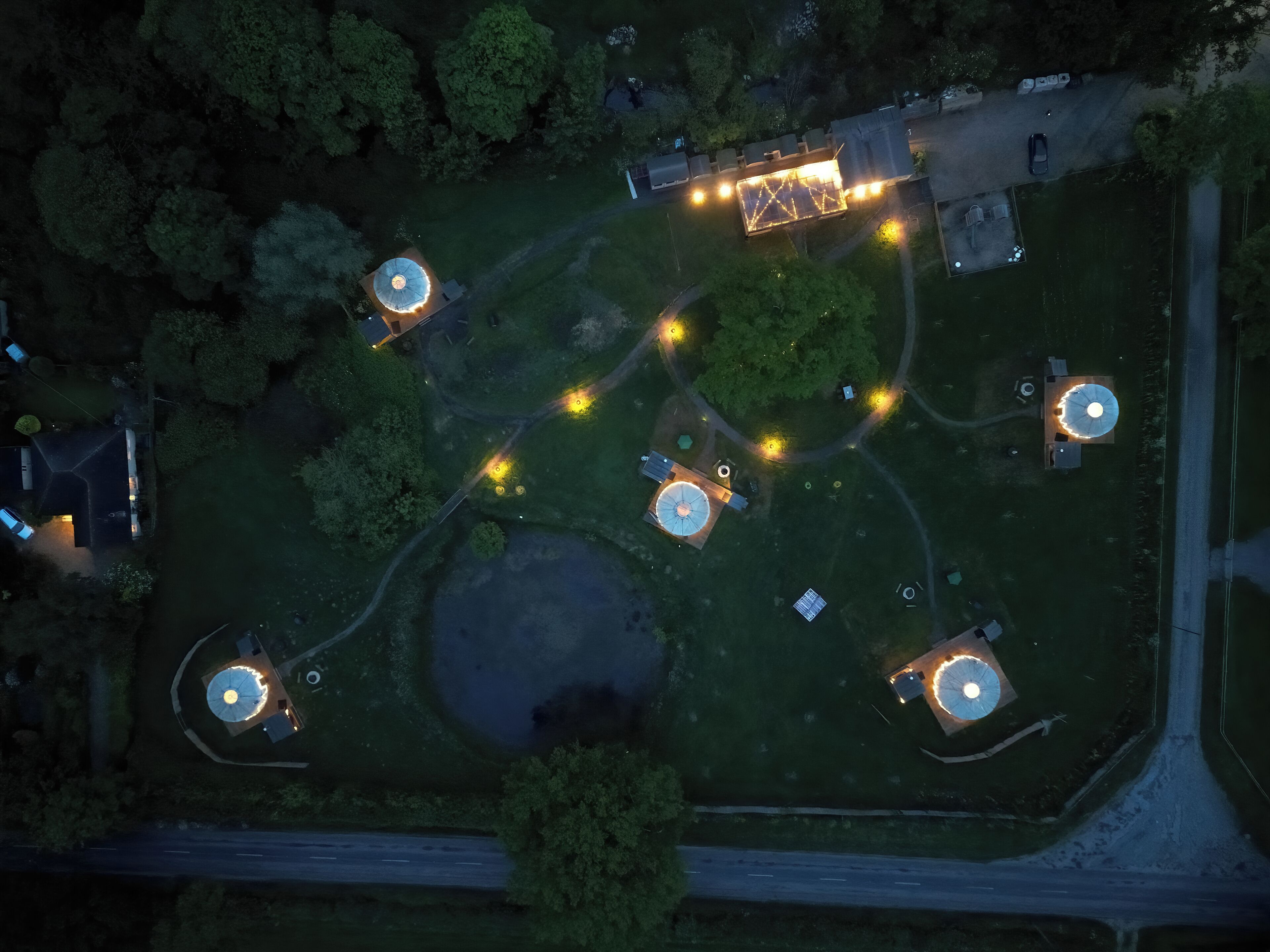 An aerial view of a property with multiple circular structures, pathways, and a central building.