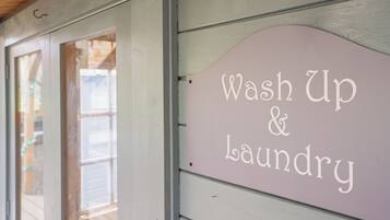 Skilt med teksten 'Wash Up & Laundry' monteret på bygning.