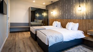 A modern hotel room with two beds, a large mirror, and a wall-mounted TV. - Aparthotel NOX (Cluj-Napoca)