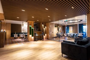 Un interior moderno con techo de madera, zona de comedor y sala de estar con sofá.