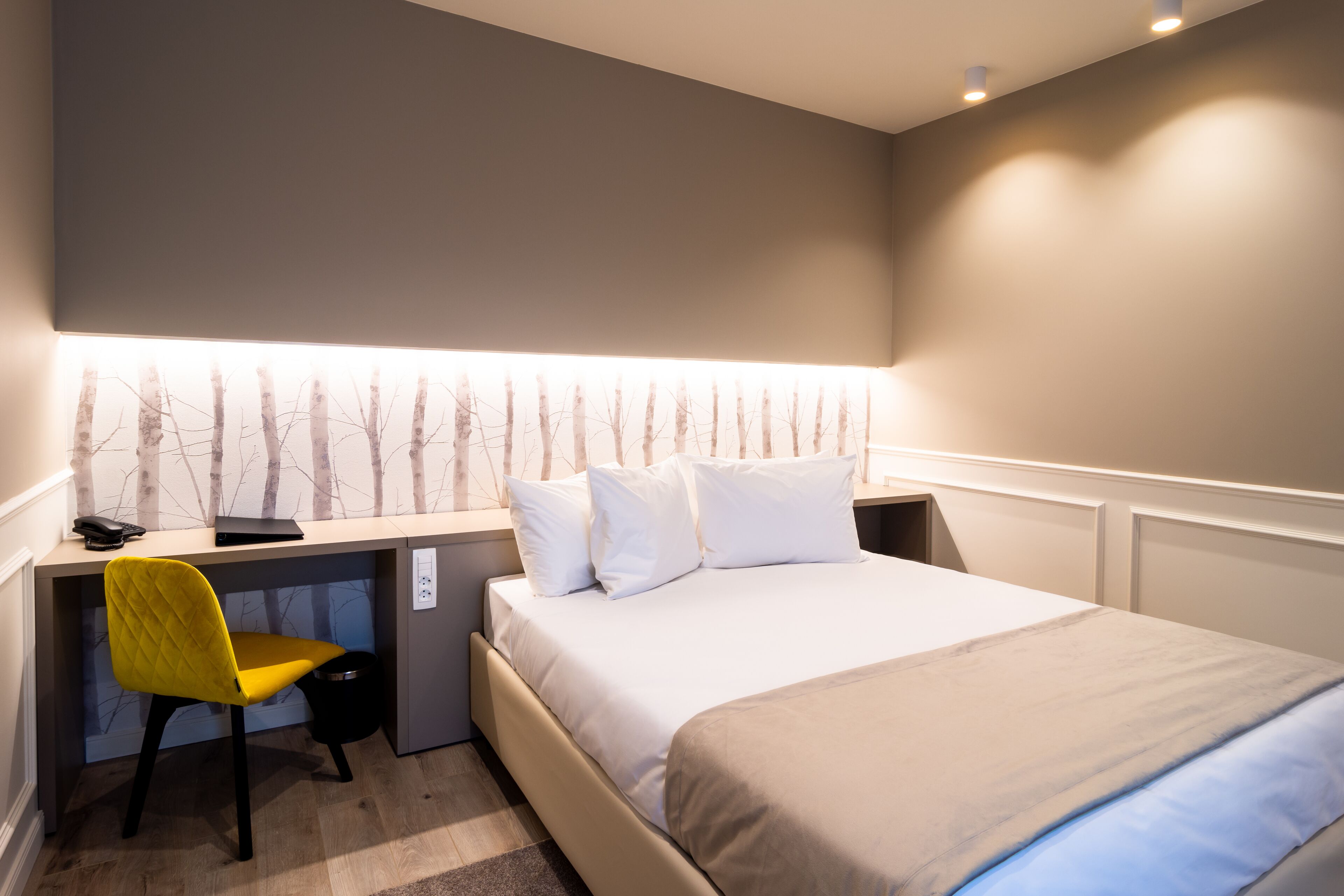 Une chambre d’hôtel avec un lit, un bureau et une chaise.