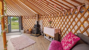 Ein gemütliches Interieur mit Holzboden, Kamin, einer Couch und einem kleinen Tisch.