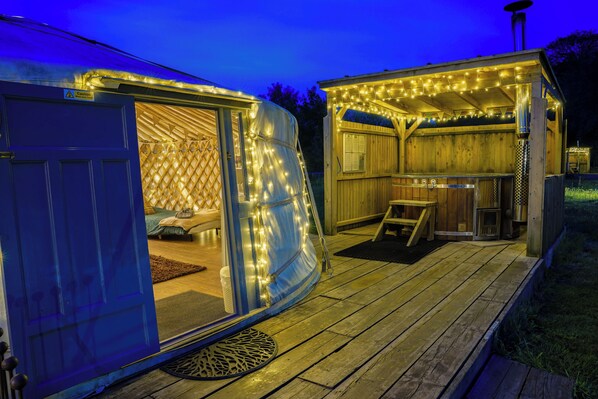 A wooden deck with a covered seating area and a small outdoor kitchen.