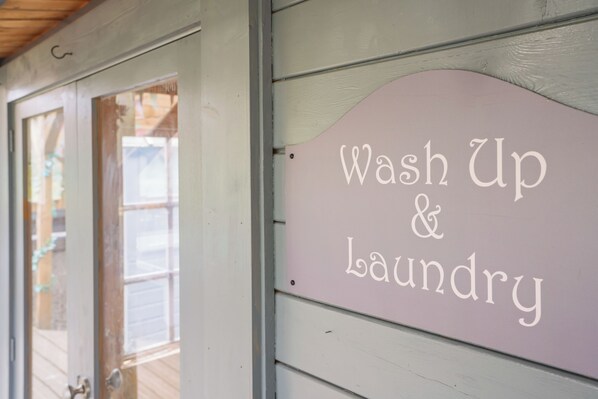 A sign that reads "Wash Up & Laundry" mounted on a building's exterior.