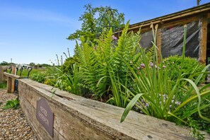 A wooden raised garden bed with a sign reading "Herb Garden." - PERIGNON Luxury Heated Yurt with Private Hot Tub (Great Ellingham)