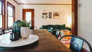 A dining area with a wooden table, two potted plants, and a white placemat. - Ultimate Group Stay in St Paul – 8 beds (Saint Paul)
