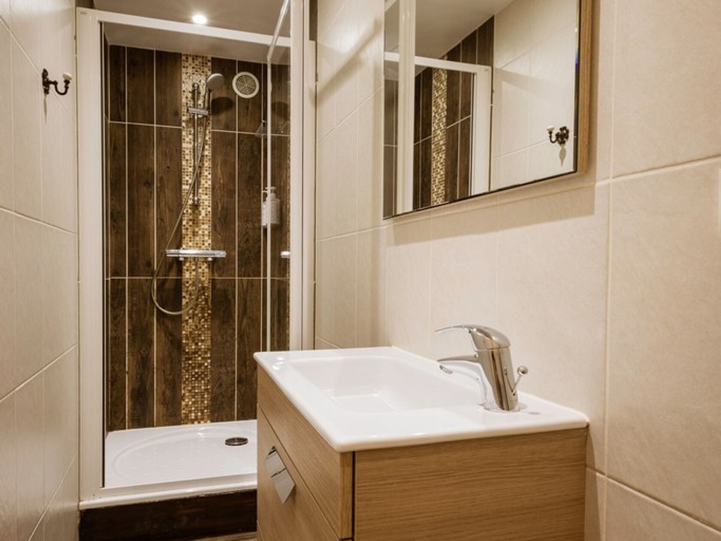 A modern bathroom with a shower, a sink, and a mirror.