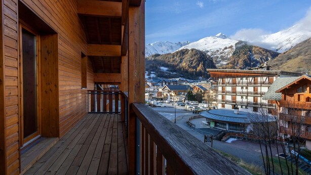 A wooden building with a balcony overlooking a snowy mountain and a town. - Duplex 4 rooms, 8 max, pets allowed, balcony (Valloire)