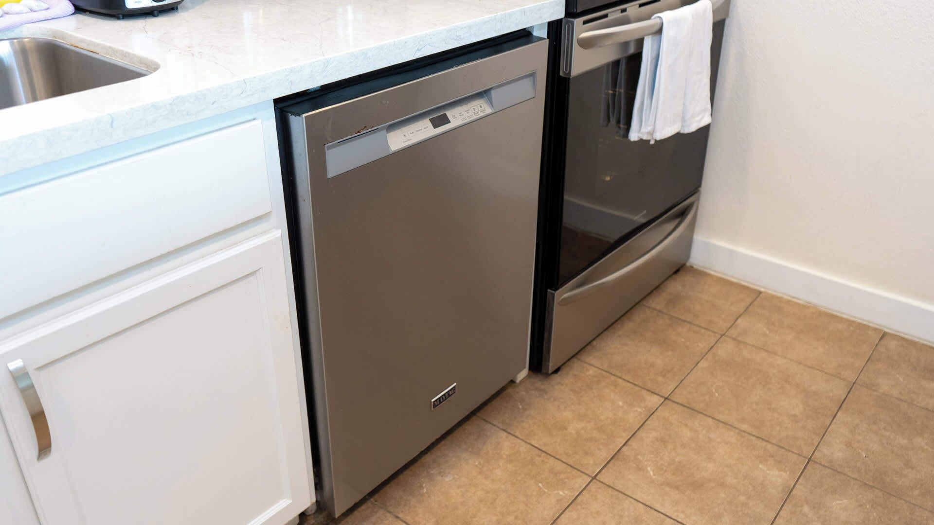 A kitchen with a dishwasher, oven, and a sink.