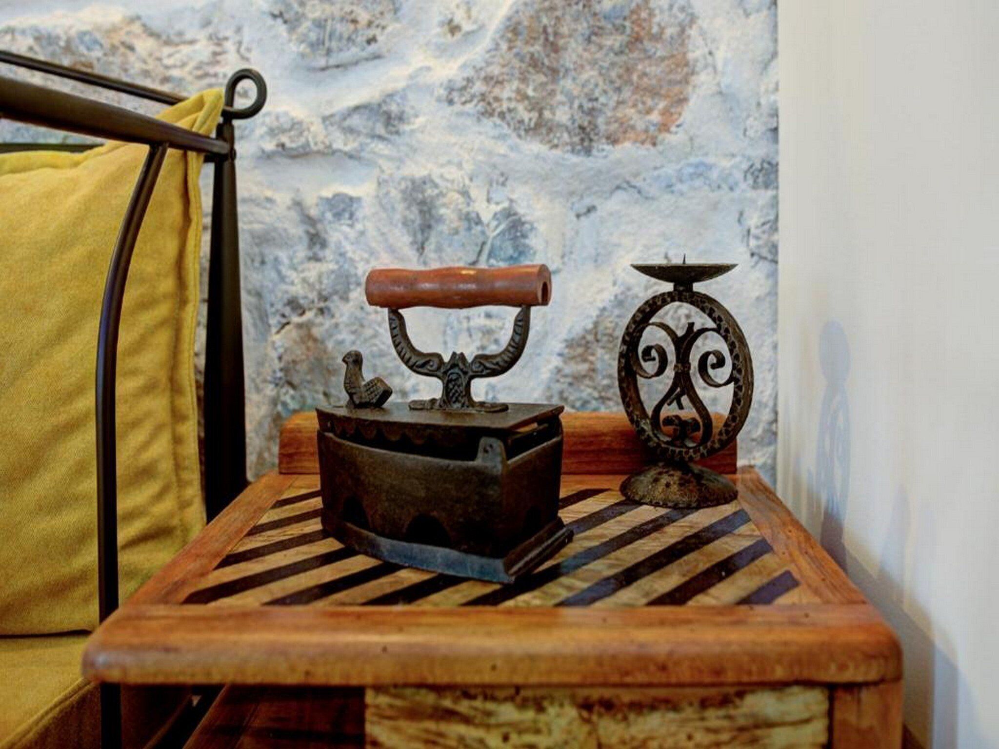 A rustic wooden table with a metal bucket, a wooden spoon, and a decorative metal piece.