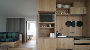 A compact kitchen with wooden cabinetry, a microwave, and a sink.