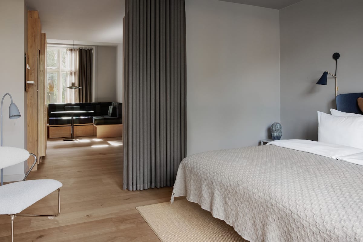 Un dormitorio moderno con una cama grande, un escritorio y una zona de estar.