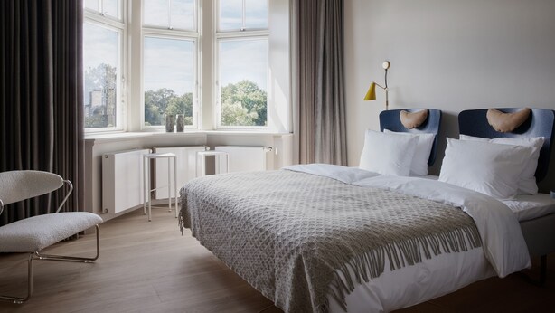 Une chambre à coucher moderne avec un grand lit, un bureau et une chaise.