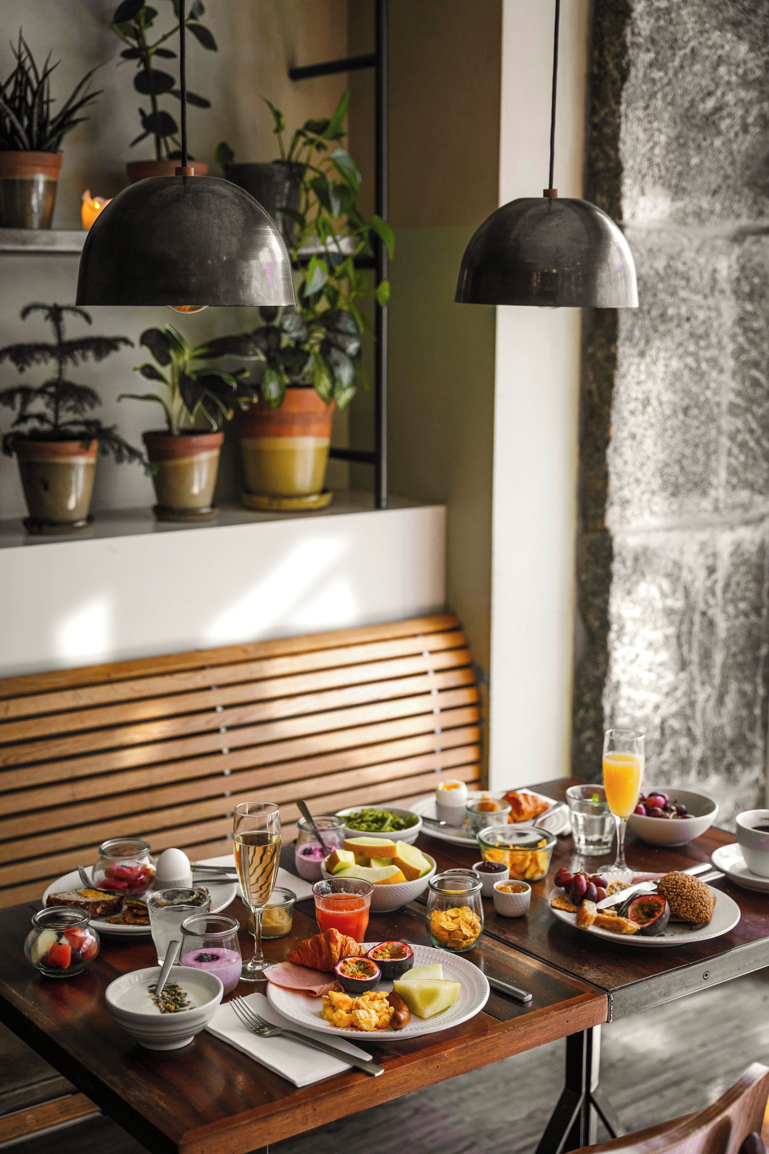A dining table set with various breakfast items, including fruits, pastries, and beverages.