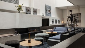 A modern lounge area with a fireplace, seating, and artwork on the walls.