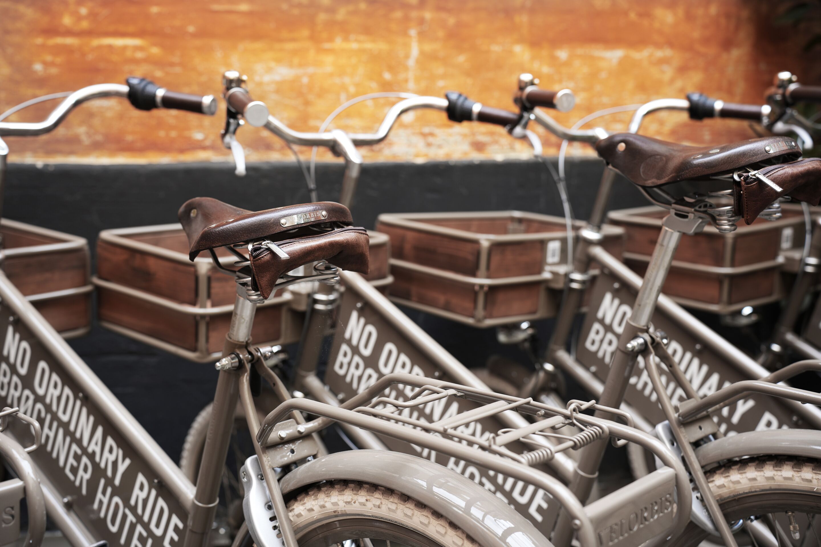 Un vélo doté d’une selle et d’un guidon en cuir, ainsi que d’un panier à l’avant et d’un porte-bagages à l’arrière.
