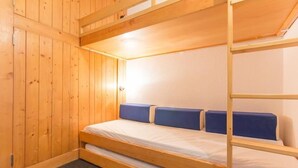 A bunk bed room with wooden walls and a carpeted floor. - 10m from ski slopes, 10th floor, balcony, tv, 28m², Les Arcs (Les Arcs)