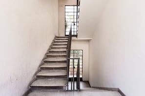 Una scala con ringhiere in metallo che conduce a un pianerottolo con una finestra.