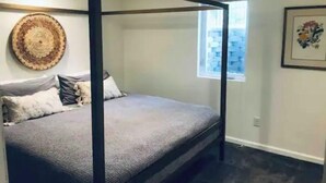 A four-poster bed in a room with a city view.