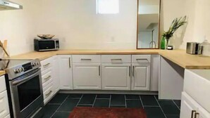 A kitchen with white cabinets, a microwave, and a stove.
