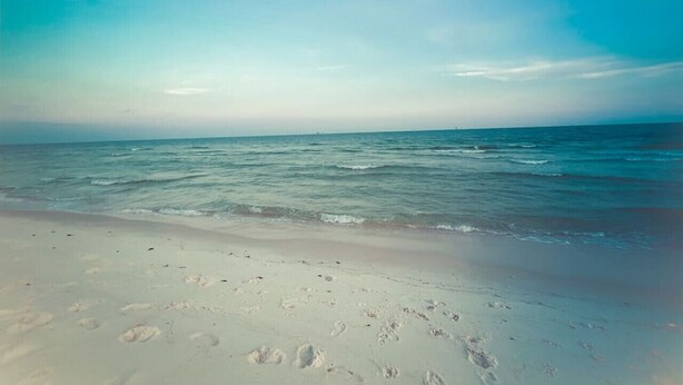 A beach with footprints in the sand and a clear sky. - Drift Away Shores · Steps to the beach!*Week Discount*Tiki Bar*2 Pools (Gulf Shores)