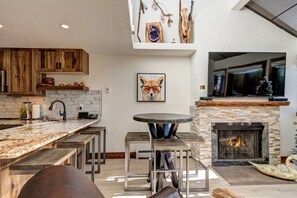 A modern kitchen with a large island, bar stools, and a fireplace. - Beaver Run Resort Ski-in/Ski-out & walk to Main St (Breckenridge)
