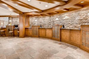 A bar area with stone walls, wooden bar counters, and a stone floor. - Beaver Run Resort Ski-in/Ski-out & walk to Main St (Breckenridge)