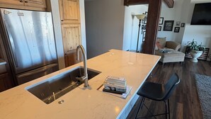 A kitchen with a large island, stainless steel appliances, and wooden cabinetry.