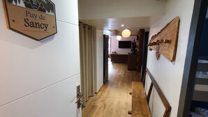 Ein Flur mit einer hölzernen Bank, einer Tür mit einem Schild und Blick in einen Essbereich.