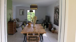 Un comedor con una mesa de madera, sillas y lámparas colgantes.