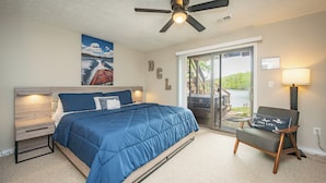 A bedroom with a bed, a chair, a ceiling fan, a window, and a door. - Cozy Dog Friendly Retreat w/ Hot Tub & Views (Mchenry)