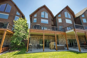 Ein mehrstöckiges Holzgebäude mit Balkonen, einer überdachten Terrasse und Steinwänden.