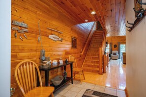 Un interior de madera con una escalera, un letrero de bienvenida y letreros que anuncian señuelos de pesca.