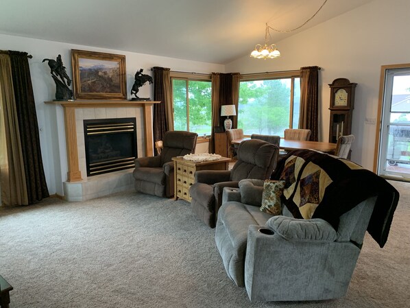 A cozy living room with a fireplace, comfortable seating, and a dining area. - Springtime in Montana - the Cottage is ready for your stay! (Billings)