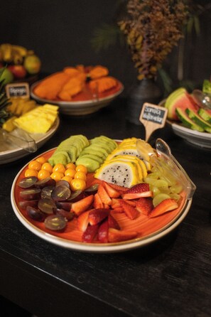 Eine Obstplatte mit verschiedenen Früchten, darunter Trauben, Erdbeeren und Kiwi.
