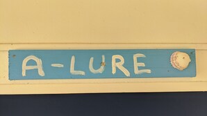 A sign with the word "A-LURE" and a seashell on a blue background. - Private Bayfront Apartment with King bed and Awesome View (Saint George Island)