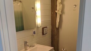 A bathroom with a white vanity, a mirror, a toilet, and a shower curtain. - Private Bayfront Apartment with King bed and Awesome View (Saint George Island)