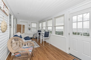 Cozy retreat with a wicker chair, small table, and door with a window.
