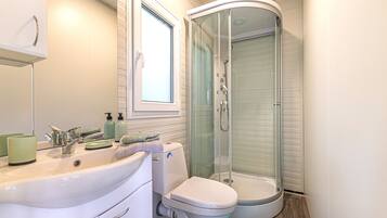 Buồng tắm vòi sen, khăn tắm, xà phòng, dầu gội