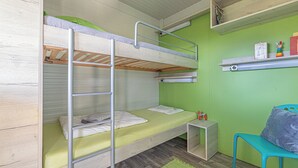 Une chambre avec un lit superposé, un bureau, une chaise et des étagères.