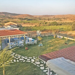 Un patio con mobiliario exterior y vistas del paisaje circundante.