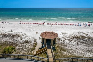 A beach with a gazebo, sandy beach, and ocean view.