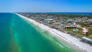 An aerial view of a coastal city with a long beach, a marina, and various buildings including hotels and residential areas. - The ONLY 1 Bedroom with a private Bunk Room - Beach Service Included!!! (Miramar Beach)