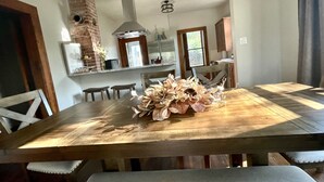 Un comedor con una mesa de madera, sillas y un centro decorativo.